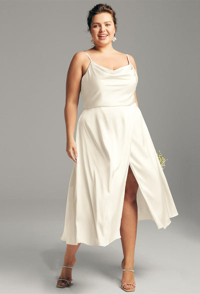 A plus size bride in a Renee - Satin Charmeuse Bridesmaid Dress - Off the Rack from Bergamot Bridal with a slit can find the perfect bridal shops in London for her special day.