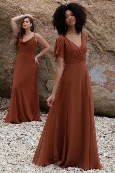 Two women modeling beautiful brown Hayes - Bridesmaid Dresses by Jenny Yoo with flutter sleeves on a pebbly beach with rocks in the background for Bergamot Bridal.