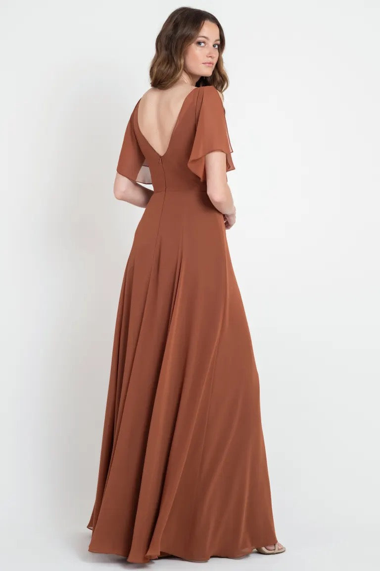 Woman posing in a Hayes - Bridesmaid Dress by Jenny Yoo, size 24, with an open back and flutter sleeves from Bergamot Bridal.