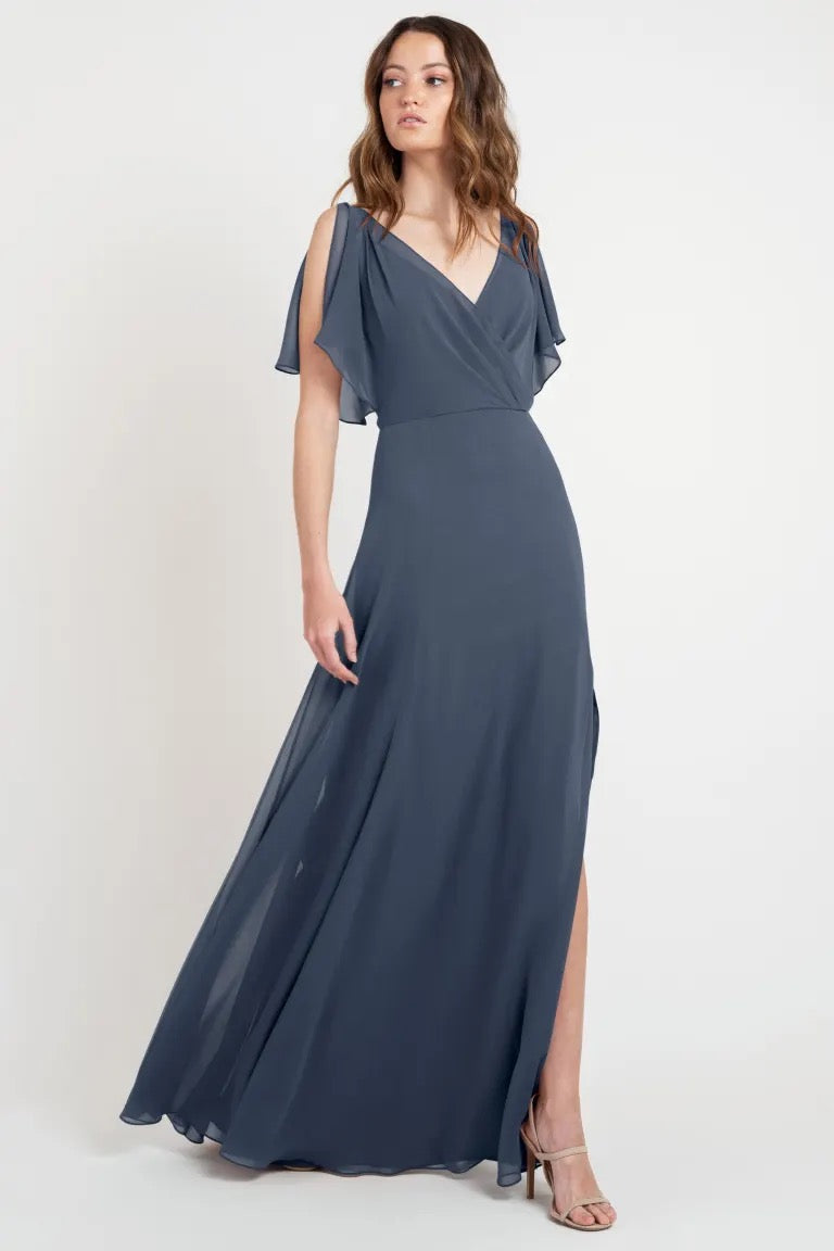 Woman in a beautiful Hayes - Bridesmaid Dress by Jenny Yoo, sample size 24, navy blue evening gown with a slit and light-as-a-feather flutter sleeves from Bergamot Bridal.