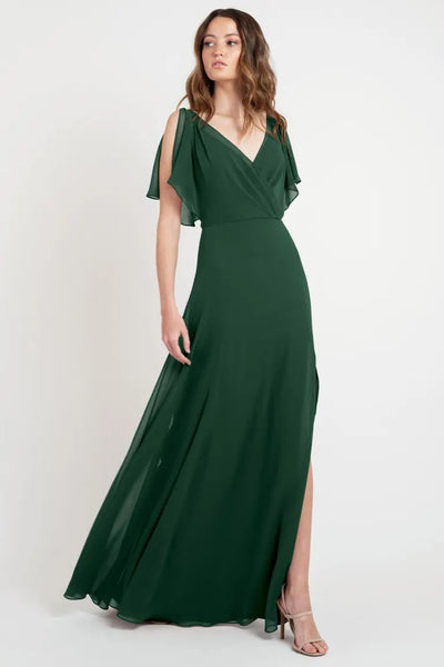 A woman in a Hayes - Bridesmaid Dress by Jenny Yoo, store sample size, with flutter sleeves and a flowing skirt from Bergamot Bridal.