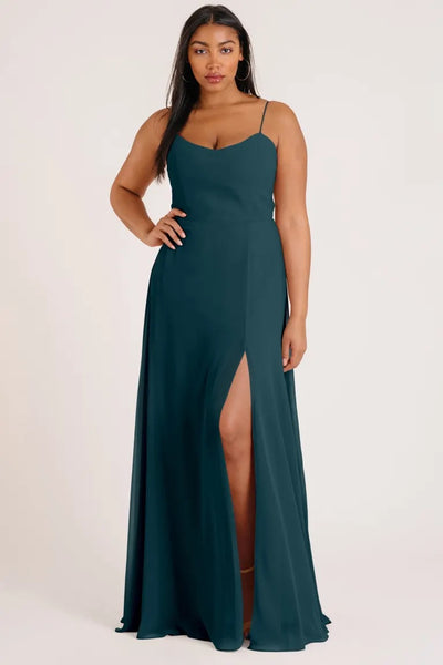 Woman posing in a luxe chiffon Kiara - Bridesmaid Dress by Jenny Yoo with a thigh-high slit from Bergamot Bridal.