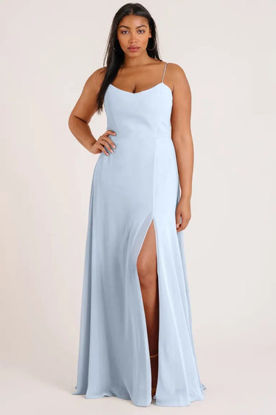 Woman posing in a light blue Kiara - Bridesmaid Dress by Jenny Yoo with a thigh-high slit and an A-line skirt from Bergamot Bridal.