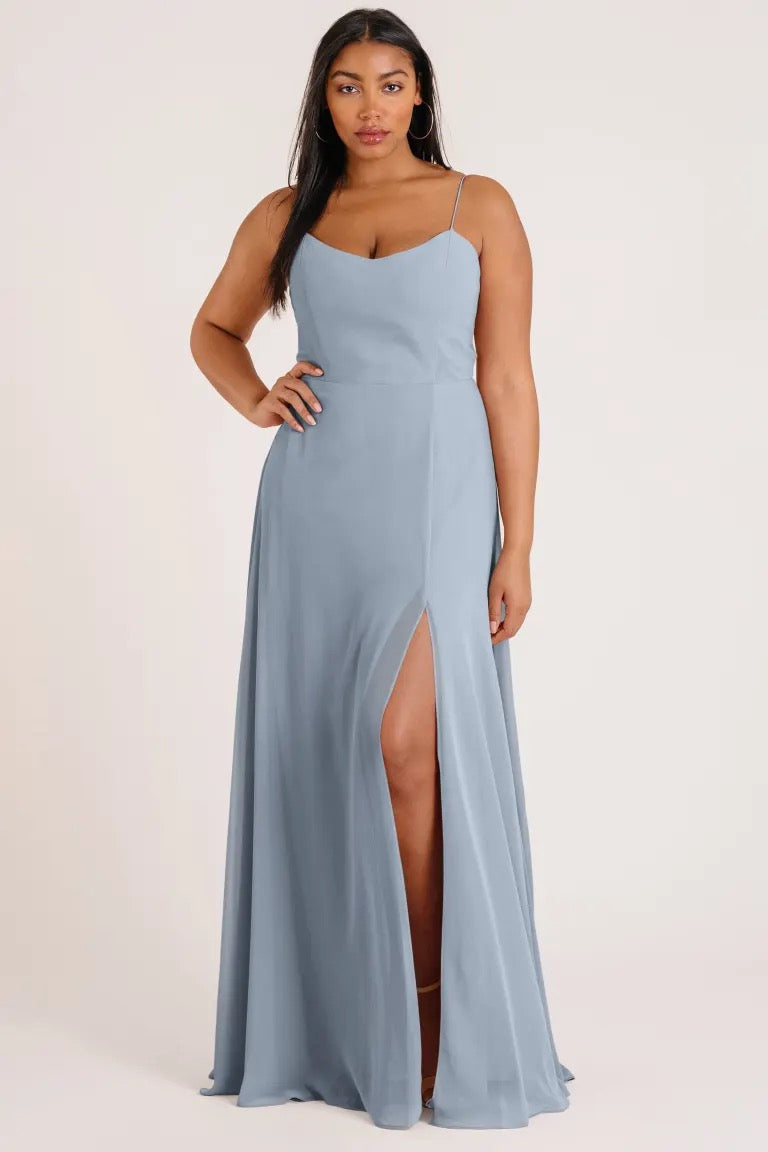 Woman posing in a light blue Kiara - Bridesmaid Dress by Jenny Yoo with a thigh-high slit from Bergamot Bridal.