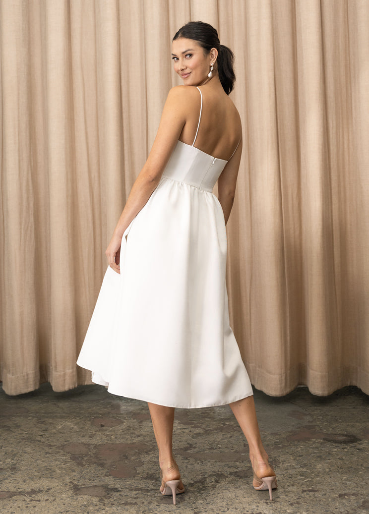 A woman showcasing the back view of her stunning Luella - Jenny Yoo Little White Dress by Bergamot Bridal.