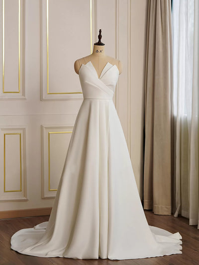 A Modern Satin A-line Wedding Dress with Slit on a mannequin in a Bergamot Bridal shop window.