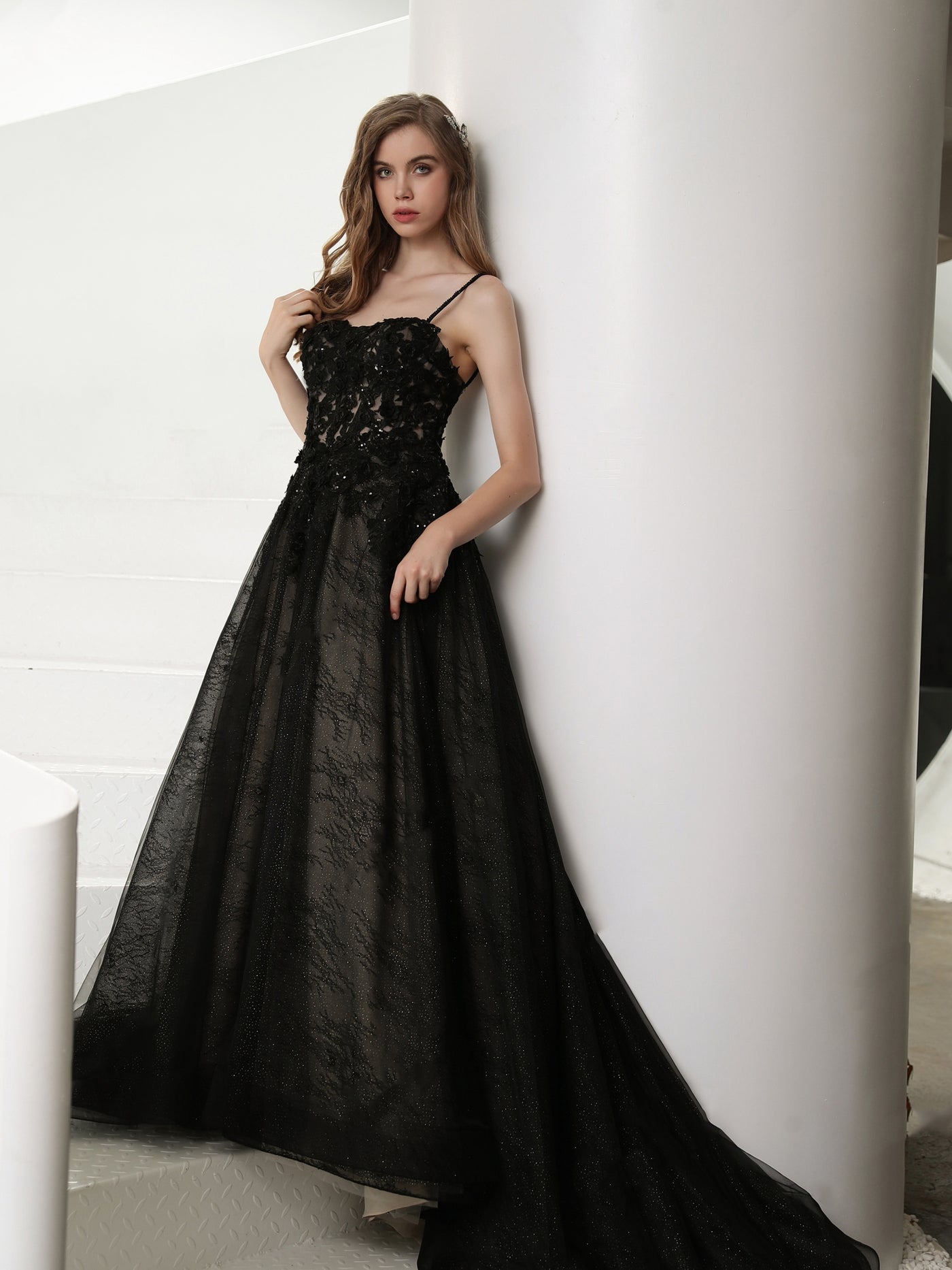 A person in a Bergamot Bridal Black Illusion Lace Wedding Dress with Detachable Long Sleeves posing against a wall.