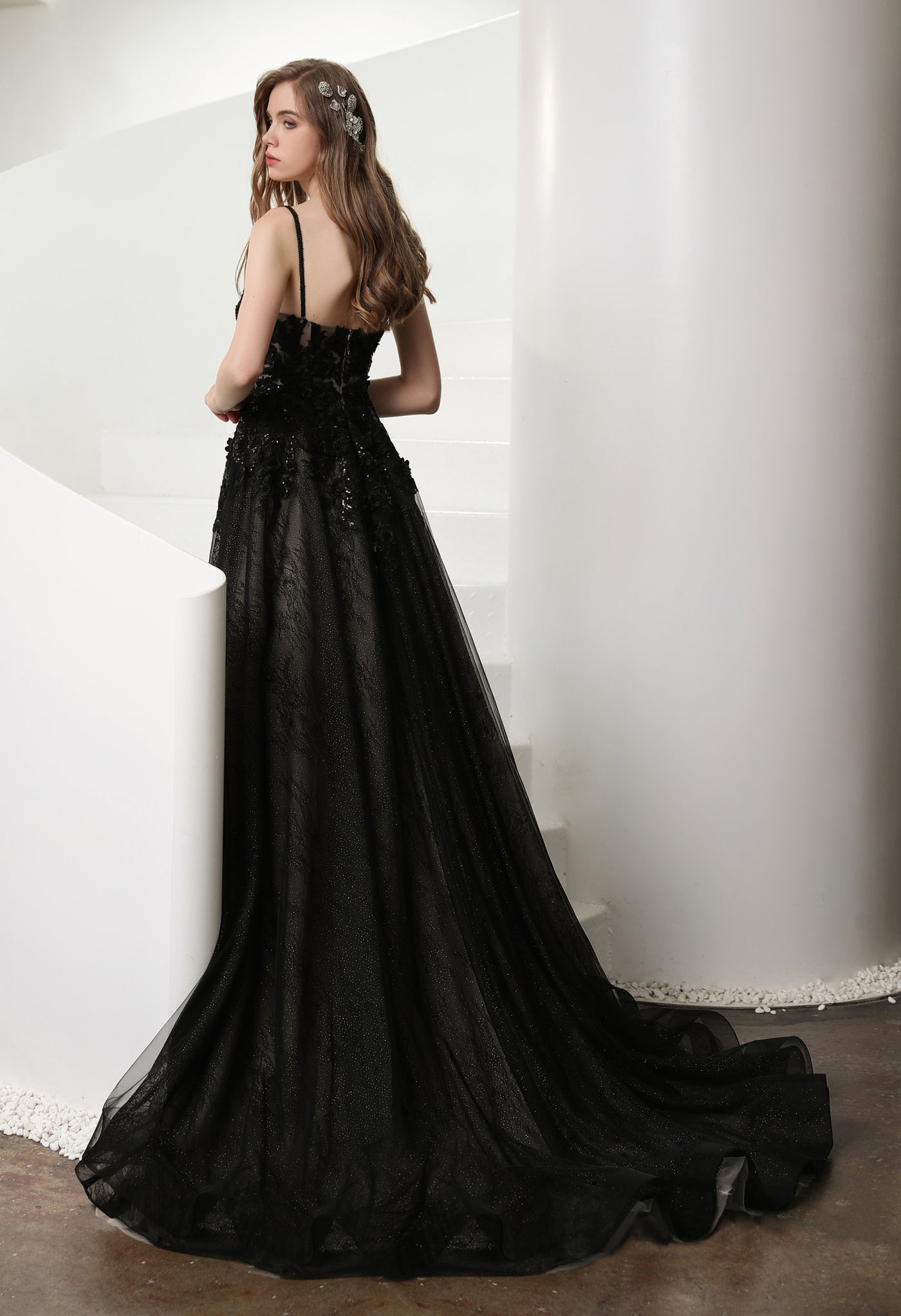 A bride in a Bergamot Bridal Black Illusion Lace Wedding Dress with Detachable Long Sleeves leaning on a staircase.
