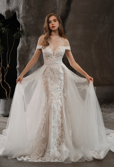 A woman modeling Bergamot Bridal's Gorgeous Lace Fit and Flare Bridal Gown with Detachable Train and a flowing veil.
