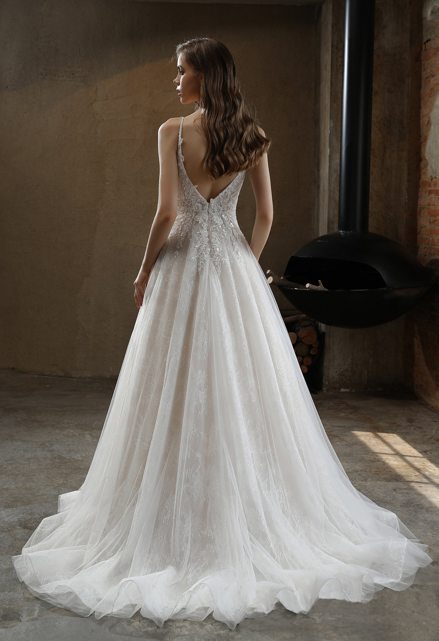 The back view of a Bergamot Bridal Beaded A-Line Wedding Dress with Spaghetti Straps at a bridal shop.