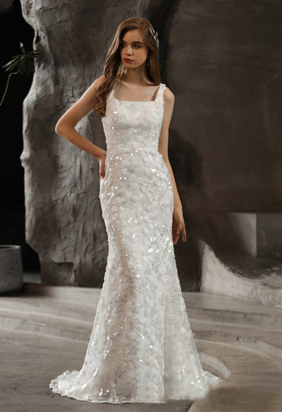A woman in an elegant white Bergamot Bridal Sequined Lace Square Neckline Sheath Wedding Dress.