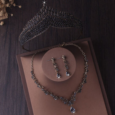 A Baroque Style Black Crystal Bergamot Bridal Jewelry Set Necklace, Earrings and Tiara displayed on a layered brown paper background.