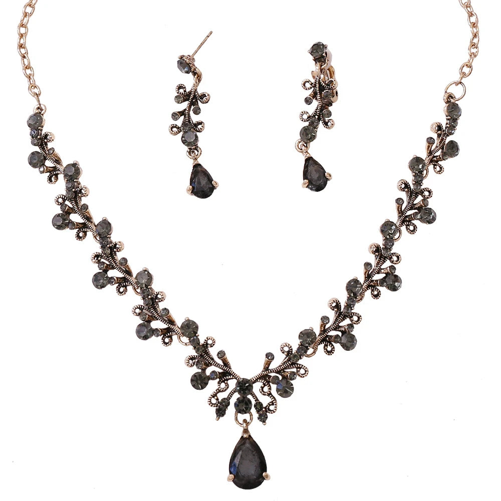 Antique bronze Baroque Style Black Crystal Bridal Jewelry Set necklace, earrings and tiara set with grey and black gemstones, displayed on a white background, ideal for complementing wedding dresses. (Bergamot Bridal)