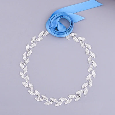 Circular diamond necklace with a crystals ribbon on a gray background.
Product Name: Silver leaf crystal bridal belt sash - Off The Rack
Brand Name: Bergamot Bridal