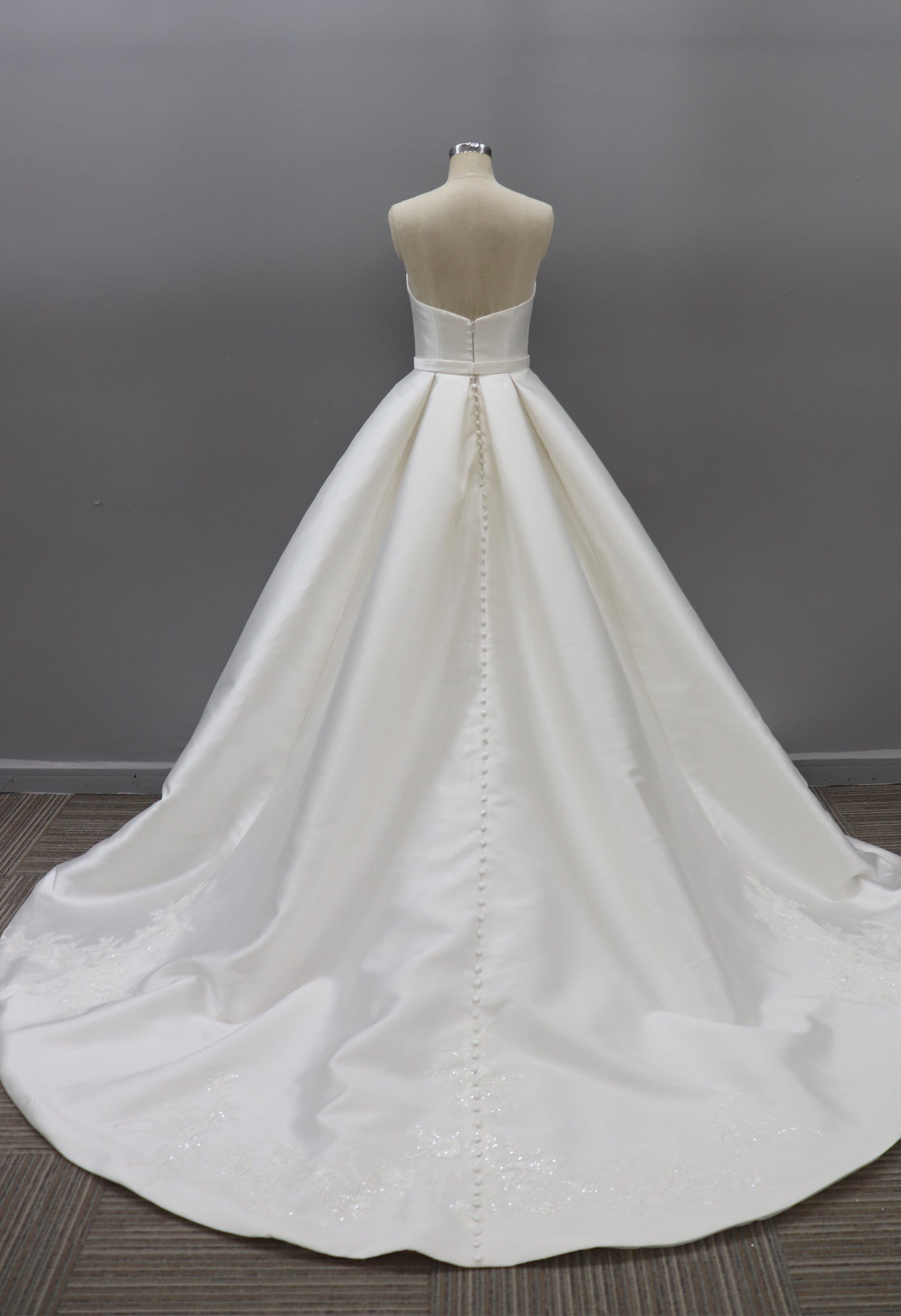 The back of a Modern Strapless Satin Ballgown With Illusion Plunge neckline in a Bergamot Bridal bridal shop.