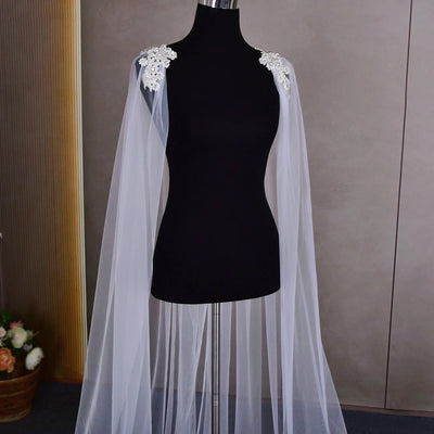 A mannequin displaying a Bergamot Bridal Bridal Cathedral Length Cape with Beaded Detail, set against a plain background in one of the bridal shops in London.