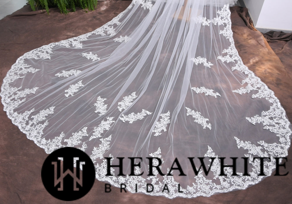 Elegant bridal veil with intricate lace detailing, displayed on a fabric surface at one of the distinguished bridal shops in London, with the logo "Bergamot Bridal" visible in the corner.