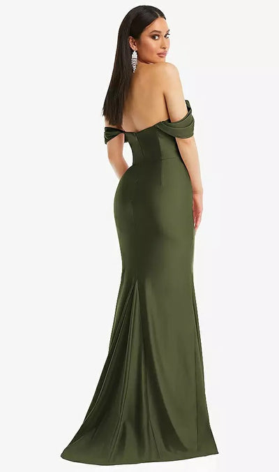 A woman in the Off-the-Shoulder Corset Stretch Satin Mermaid Bridesmaid Dress with Slight Train by Bergamot Bridal (Style CS101) is elegantly posed, looking over her shoulder. The olive green gown beautifully accentuates her silhouette, and her look is enhanced by prominent earrings and long dark hair.