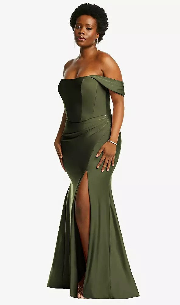 A woman confidently poses against a plain background, exuding elegance in the Off-the-Shoulder Corset Stretch Satin Mermaid Bridesmaid Dress with Slight Train (Style CS101 by Dessy) in olive green, from Bergamot Bridal.