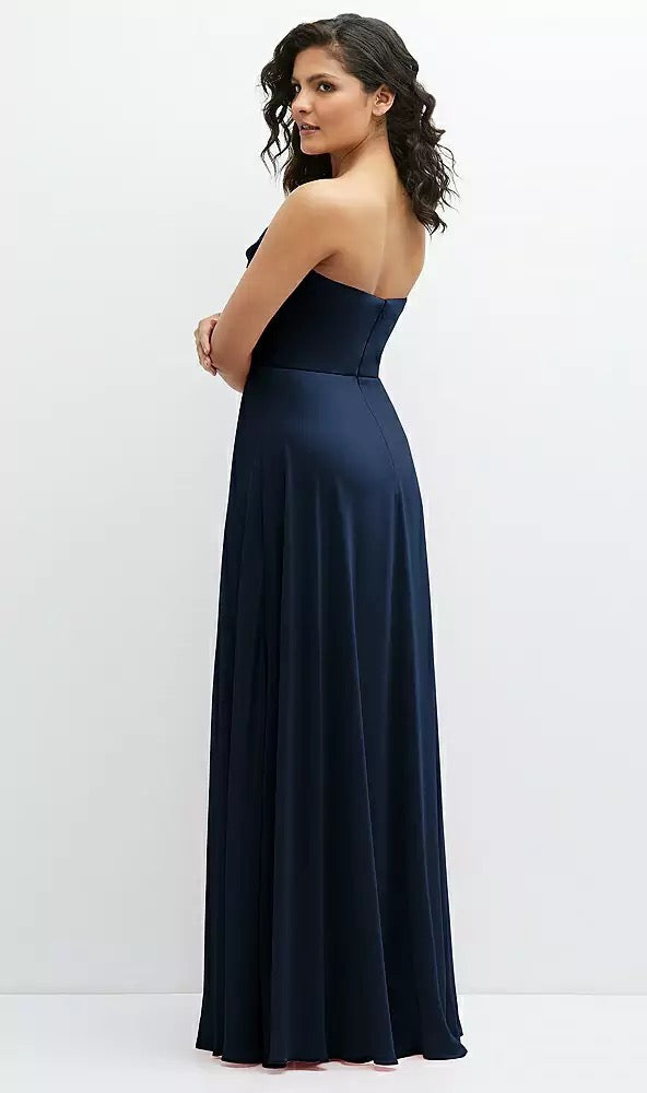 A woman in a Chiffon Corset Maxi Dress with Removable Off-the-Shoulder Swags Bridesmaid Dress - Style 1577 by Dessy from Bergamot Bridal poses with her back to the camera against a plain white backdrop, exuding an elegant and luxurious aesthetic.