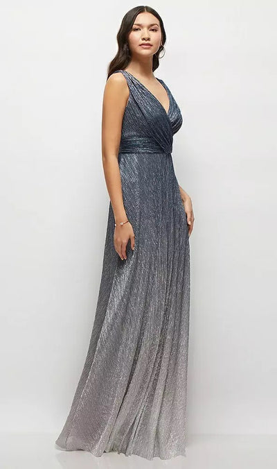 Against a neutral backdrop, a woman stands gracefully wearing the Draped V-Neck Ombre Pleated Metallic Maxi Bridesmaid Dress by Bergamot Bridal, featuring an elegant sleeveless design with a dramatic deep V-back and chic shirred waist.