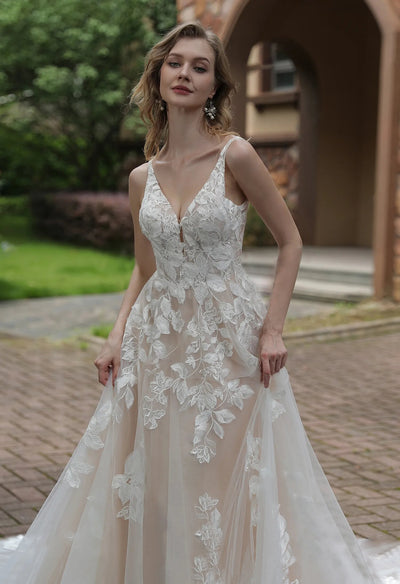 A woman wearing a Bergamot Bridal Luxurious Floral Lace A-Line Wedding Dress With Sheer Train.