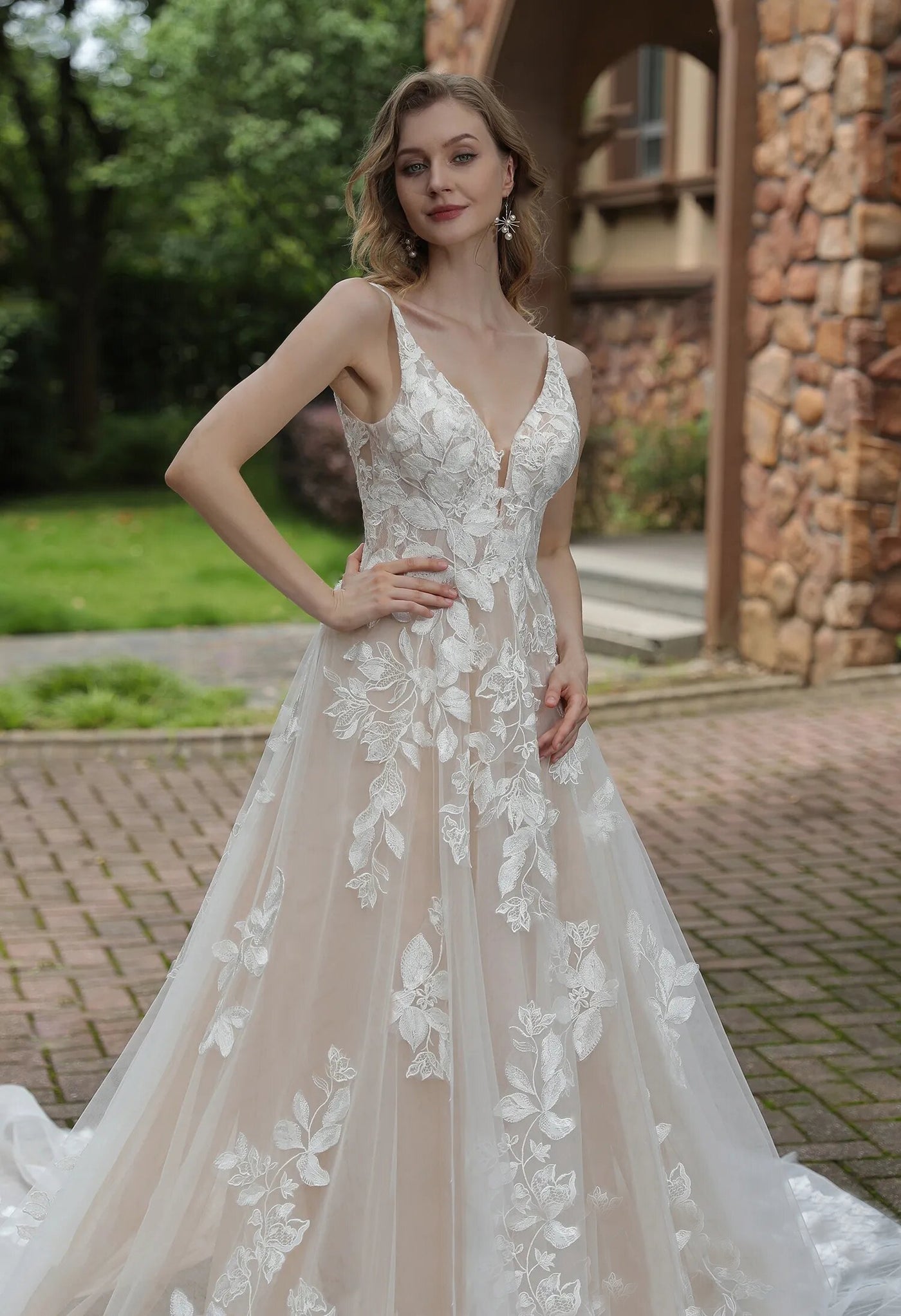 A beautiful Luxurious Floral Lace A-Line Wedding Dress With Sheer Train and v-neck with appliques is available at bridal shops in London from Bergamot Bridal.