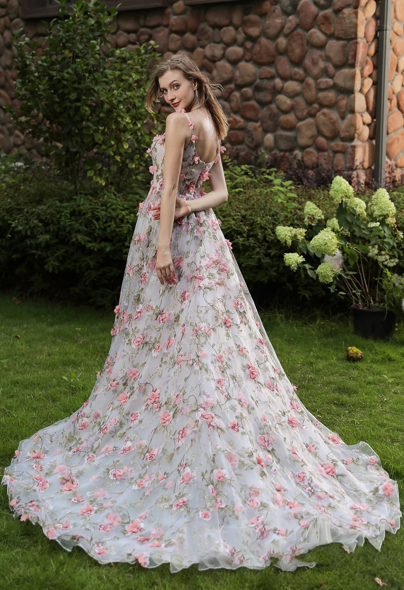 The back of a woman in a Romantic Square Neckline with 3D Flowers Bridal Gown With Detachable Sleeves by Bergamot Bridal at a bridal shop in London.