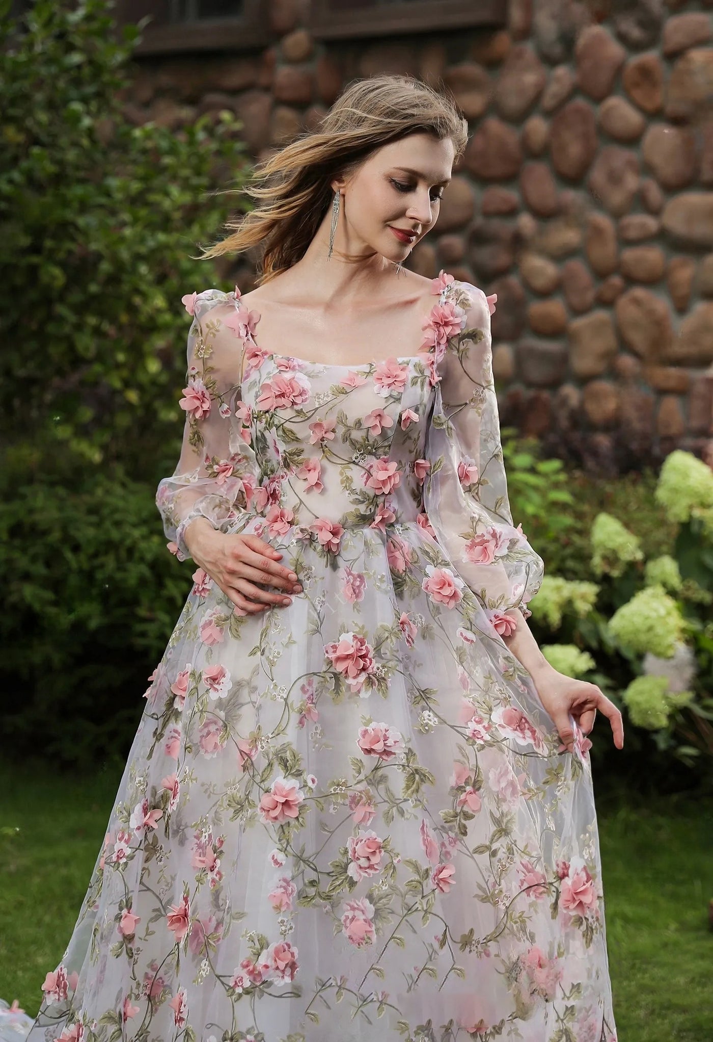A woman in a Bergamot Bridal pink floral wedding dress, Romantic Square Neckline with 3D Flowers Bridal Gown With Detachable Sleeves.