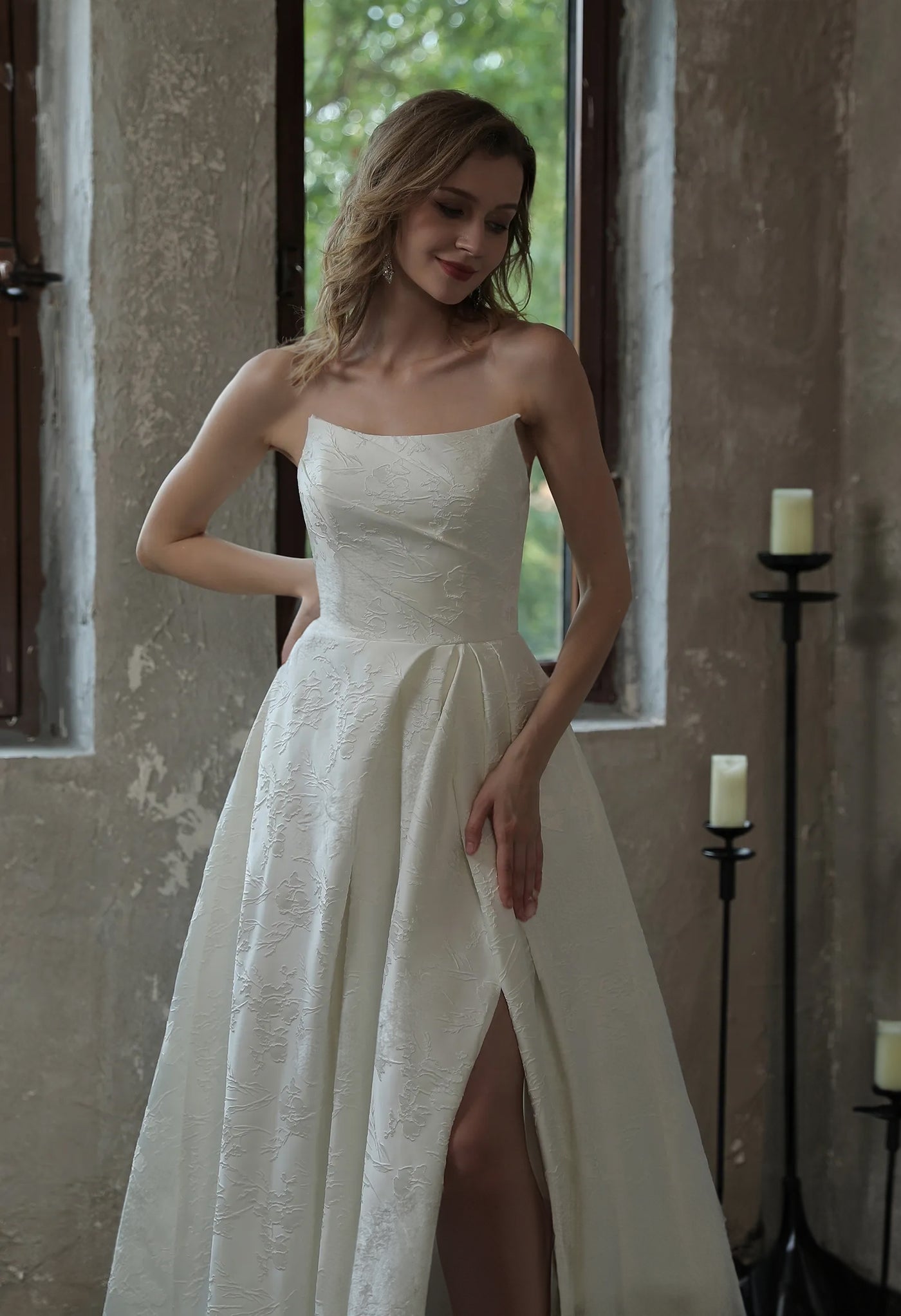 A woman in a white wedding dress by Bergamot Bridal posing in front of a window at a bridal shop in London.