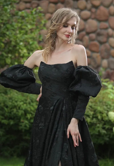 A woman in a black dress posing outdoors for Bergamot Bridal's Modern Scoop Neckline Brocade Satin Ball gown.
