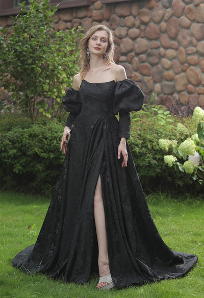 A woman is posing in a black evening dress, the Modern Scoop Neckline Brocade Satin Ball gown, at Bergamot Bridal in London.
