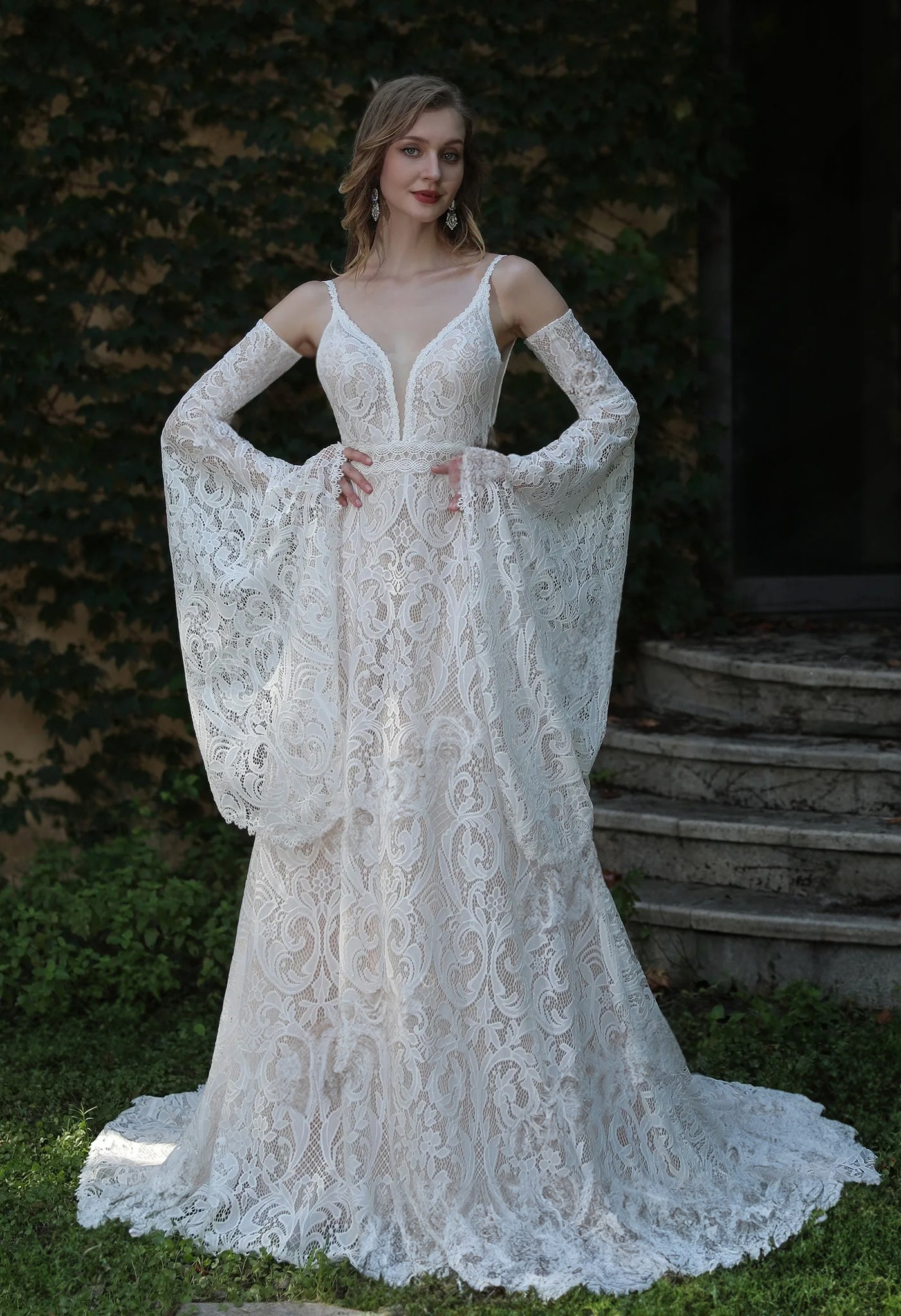A Boho Lace Wedding Dress With Spaghetti Straps and Removable Bell Sleeves available at Bergamot Bridal, a bridal shop in London.