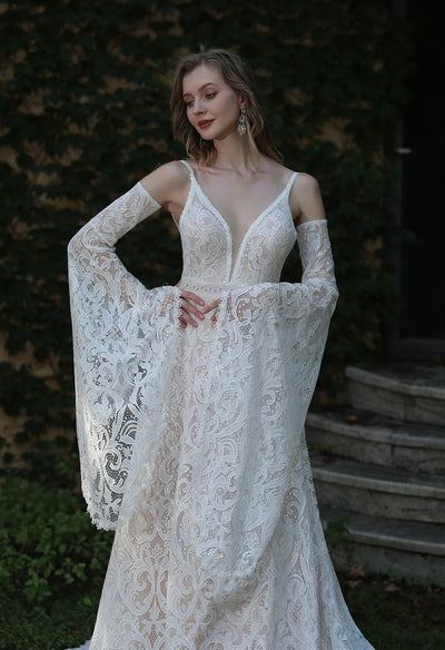 The bride is wearing a Bergamot Bridal Boho Lace Wedding Dress with Spaghetti Straps and Removable Bell Sleeves.