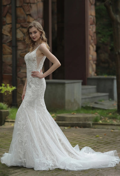 A woman in a Bergamot Bridal Classic V-Neck Allover Lace Fit And Flare Wedding Dress posing outdoors.