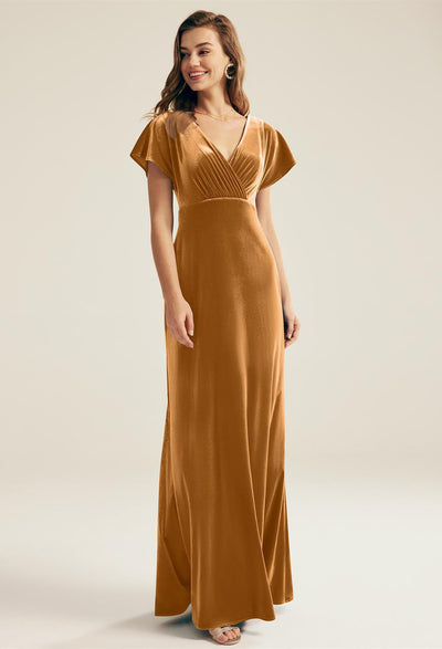 A woman wearing a brown Meara - Velvet Bridesmaid Dress - Off The Rack by Bergamot Bridal.