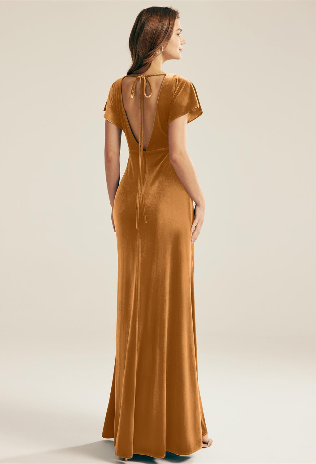 The back view of a woman wearing a Meara - Velvet Bridesmaid Dress - Off The Rack by Bergamot Bridal at a bridal shop in London.