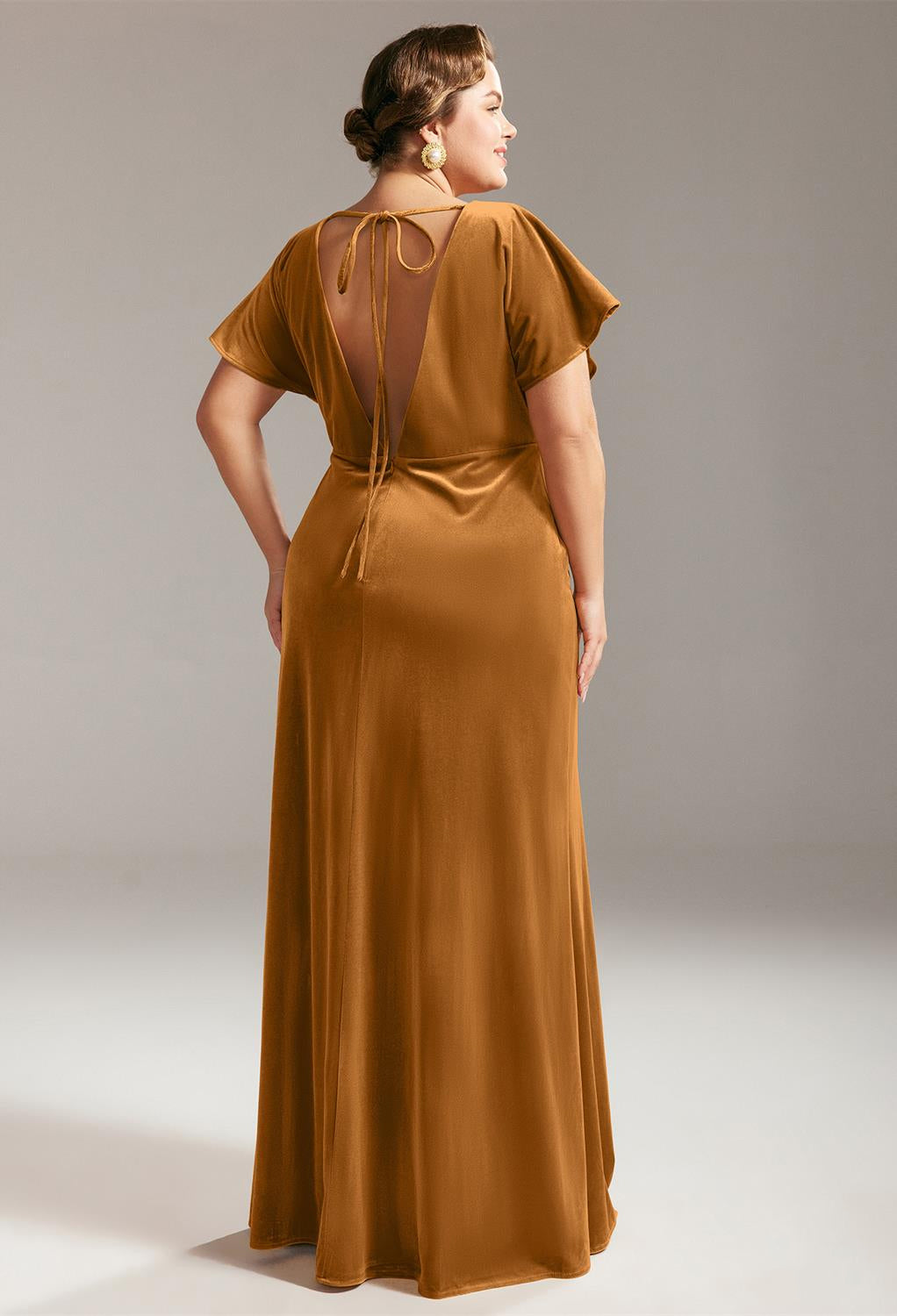 The back view of a plus size woman wearing the Meara - Velvet Bridesmaid Dress - Off The Rack gown for a bridesmaid dress in London by Bergamot Bridal.