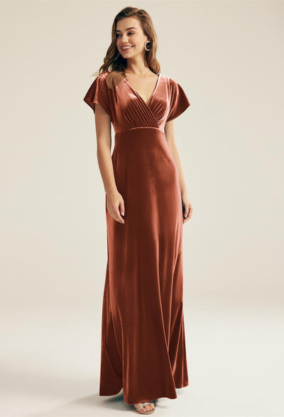 A woman wearing a brown Meara - Velvet Bridesmaid Dress - Off The Rack by Bergamot Bridal.
