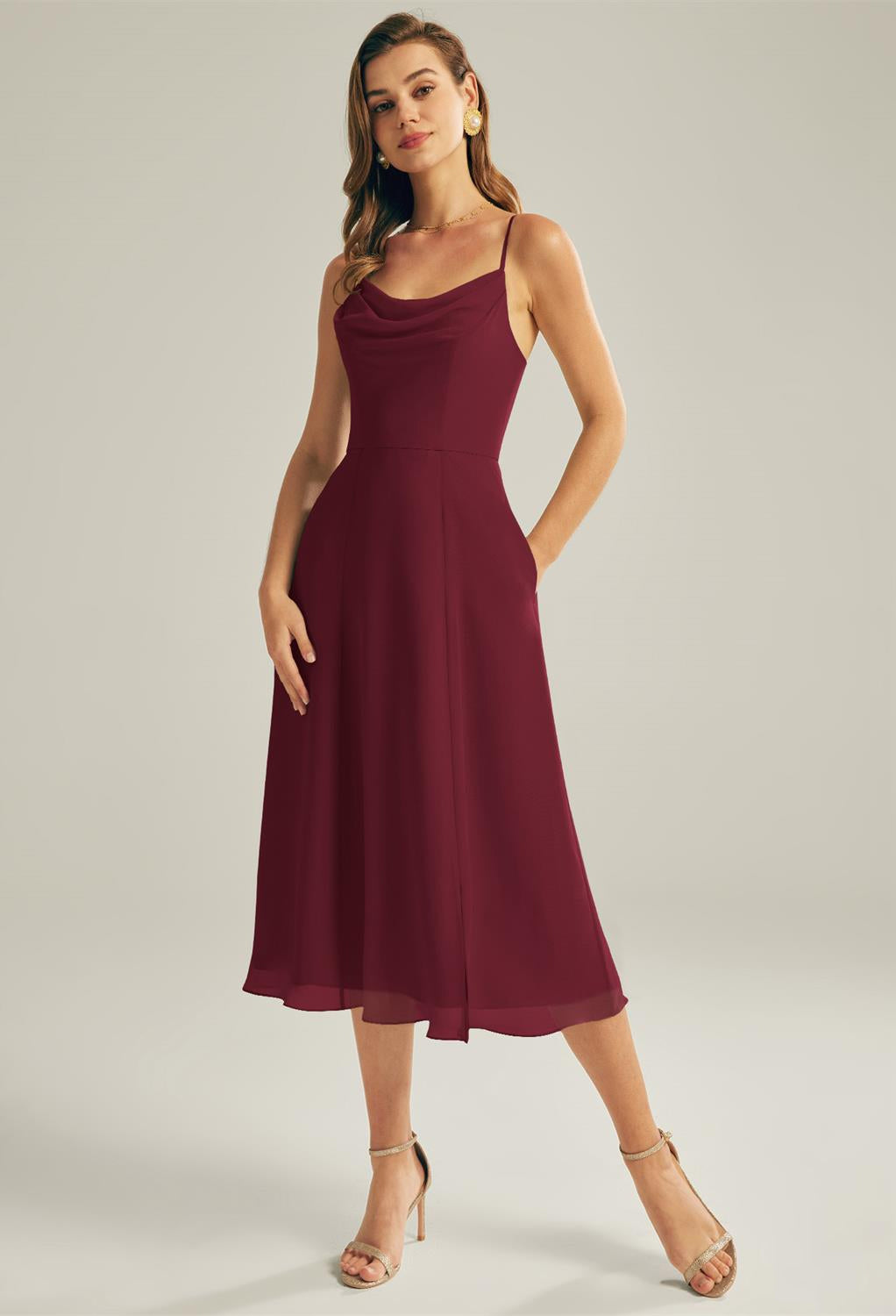 A woman stands gracefully, showcasing the Maribel - Chiffon Bridesmaid Dress from Bergamot Bridal, paired with beige heels against a plain background, exuding the elegance typical of affordable bridal selections from a wedding boutique in London, Ontario.