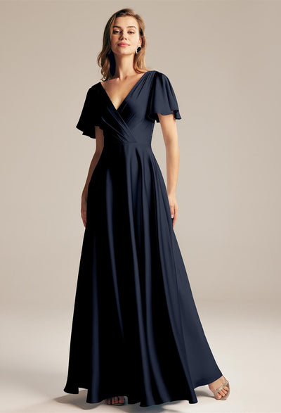 The Furst - Satin Charmeuse Bridesmaid Dress - Off The Rack from Bergamot Bridal in London is navy blue with a v - neck and flutter sleeve.