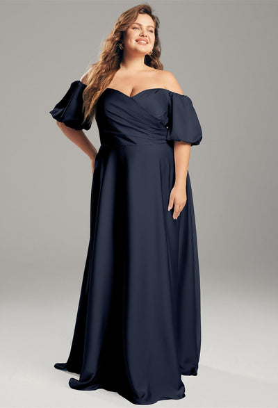 A plus size woman in a navy off the shoulder Dey - Satin Charmeuse Bridesmaid Dress - Off The Rack by Bergamot Bridal.