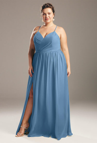 Woman in a blue Wilfreda - Chiffon Bridesmaid Dress - Off The Rack standing confidently against a neutral background by Bergamot Bridal.