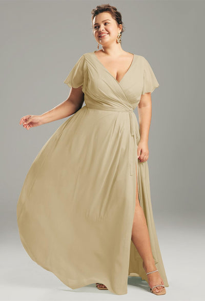 In a studio setting, a person wears an Ellison chiffon bridesmaid dress with short sleeves and a slit from Bergamot Bridal, capturing the elegant style found in bridal shops across London, Ontario.