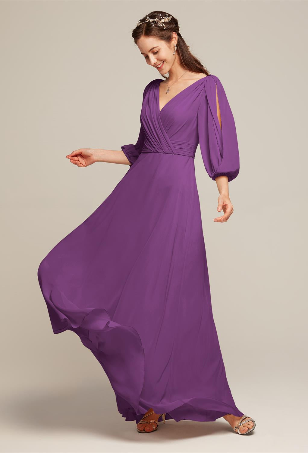 A person wearing the Polly Chiffon Bridesmaid Dress from Bergamot Bridal stands gracefully against a plain backdrop, embodying the elegance perfect for any wedding.