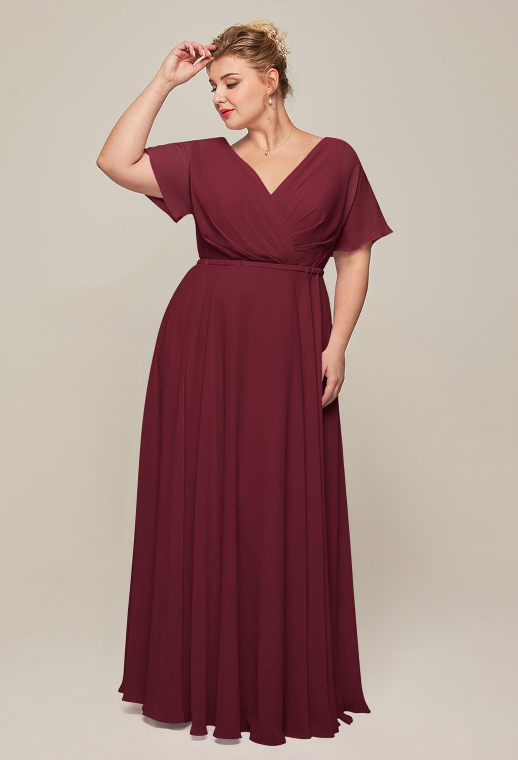 A woman in a red Ginny - Chiffon Bridesmaid Dress - Off The Rack by Bergamot Bridal.