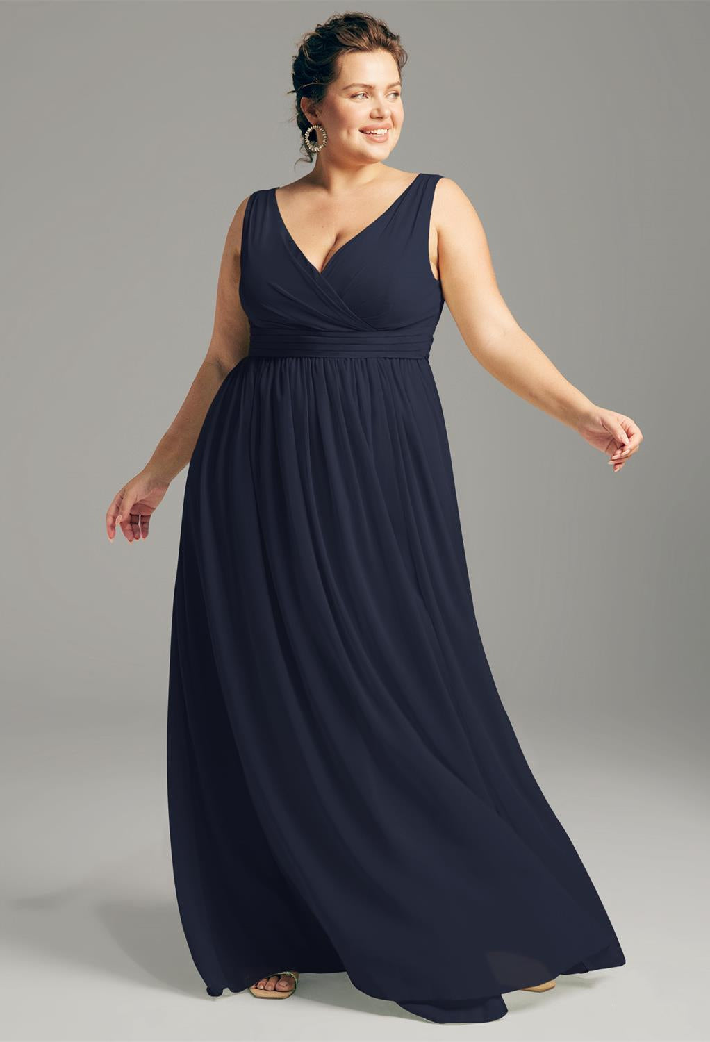 A plus size bridesmaid in a navy blue Hilaria - Chiffon Bridesmaid Dress - Off the Rack by Bergamot Bridal shopping at a bridal shop in London.