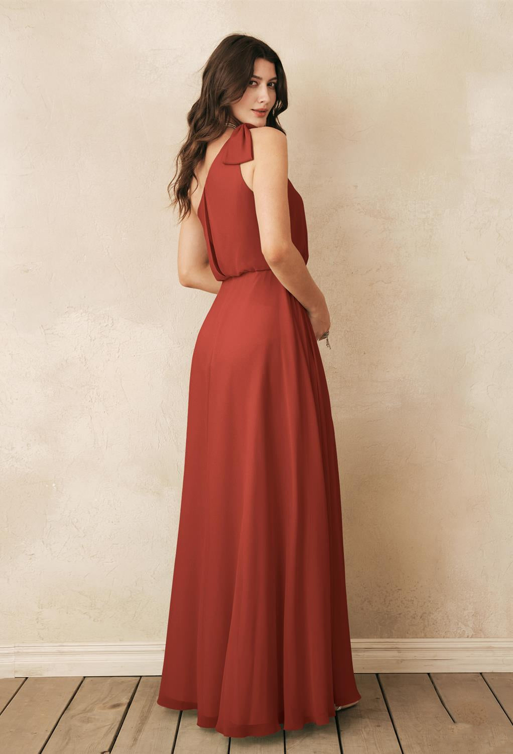 The back view of a woman wearing a Robina - Chiffon Bridesmaid Dress - Off The Rack in a Bergamot Bridal shop in London.