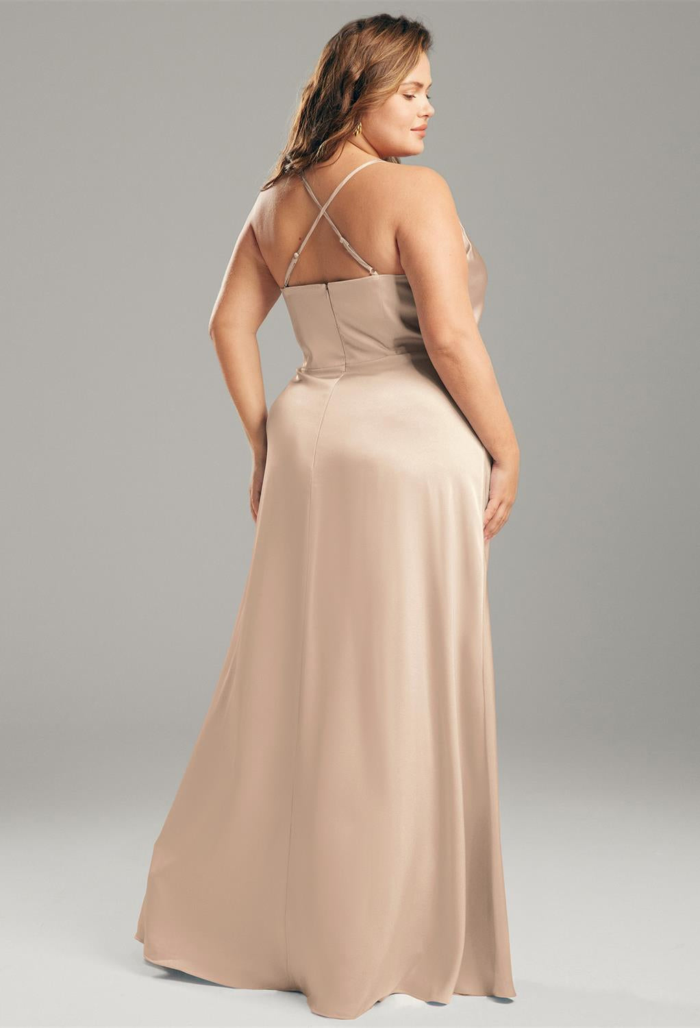 The back view of a Kora - Satin Charmeuse Bridesmaid Dress - Off The Rack in a beige gown at Bergamot Bridal in London.