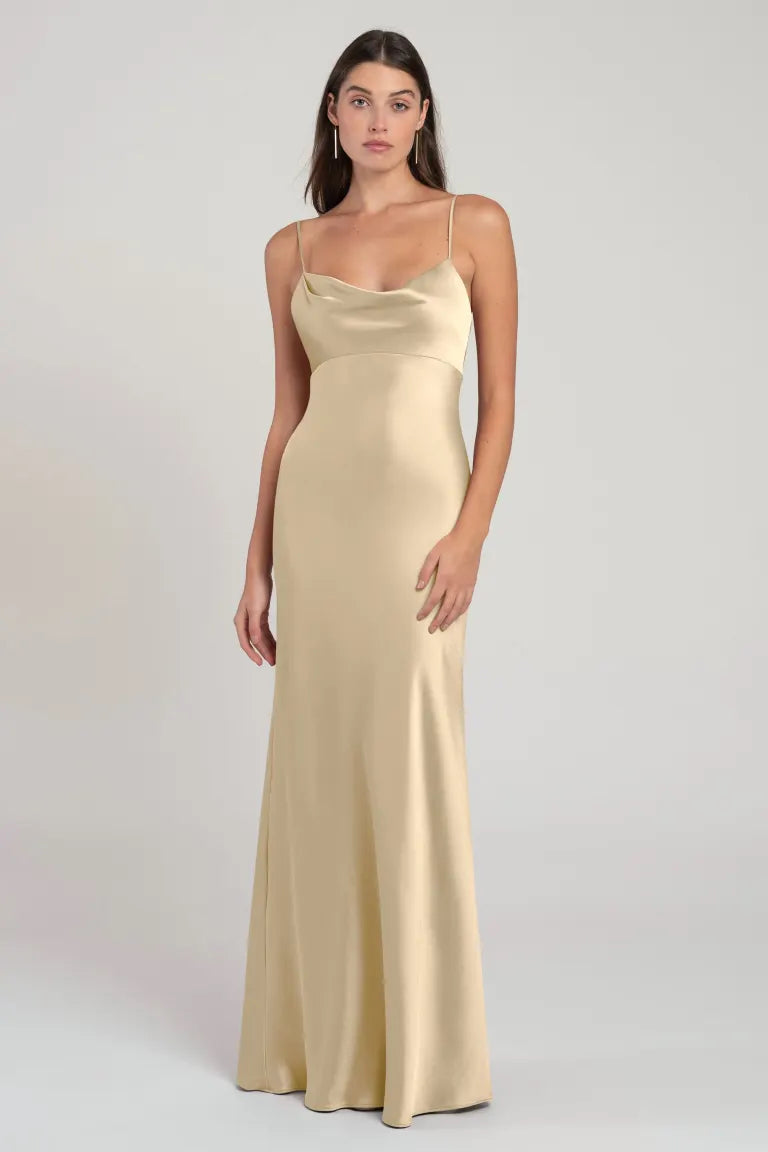 Woman in a simple elegant Addison - Bridesmaid Dress by Jenny Yoo standing against a neutral background.